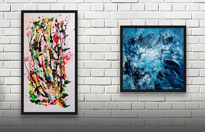 To farverige abstrakte malerier på en hvid murstensvæg